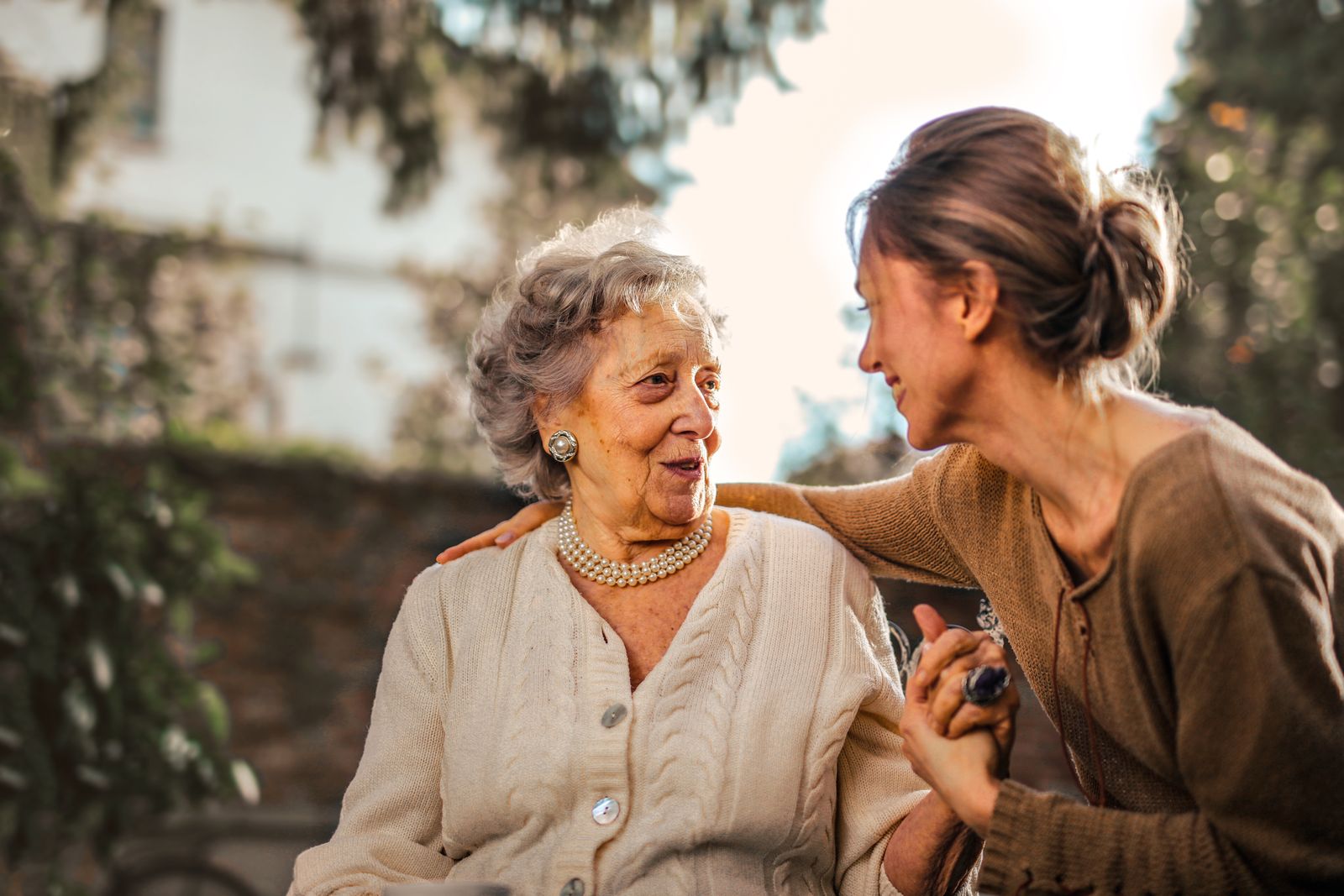 An older woman talking with a younger companion outdoors